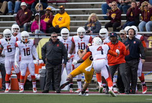 Syracuse cornerback Brandon Reddish attempts to wrap up a Central Michigan ball carrier as the SU sideline looks on during its 40-3 win.