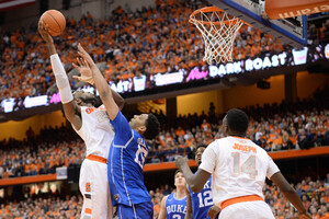 Rakeem Christmas goes up for a right-handed hook shot against Duke freshman Jahlil Okafor. The SU senior lost the battle down low, as Okafor logged 23 points and 13 rebounds against Christmas on Saturday night.