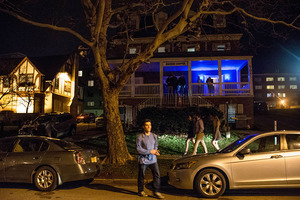 People congregate outside of Zeta Beta Tau Fraternity house on campus for a party. 