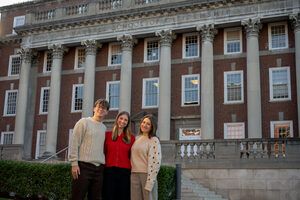 Tyler Branigan (left), Olivia Reid (middle) and Jenna Poma (right) stand in front of the Maxwell School of Citizenship and Public Affairs. The three's contributions ensure Slice Consulting is an empowering organization at Syracuse University.