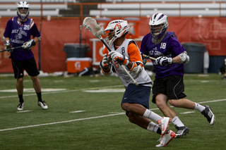 Syracuse midfielder Hakeem Lecky rushes around an opposing defender.