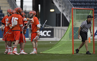 Syracuse players huddle up in celebration after a goal. 