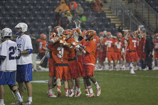 Syracuse players celebrate in the rain after a game-winning rally. 