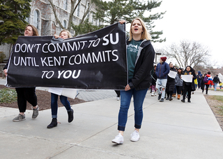 (From right) Lindsey Dierig, Perrine Wasser and Hayley Bermel hold a banner while protesting.