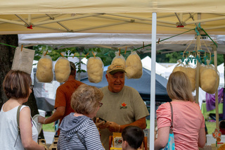 One of the vendors from SweeTrees Maple Products promotes his maple cotton candy to a family as they approach the stand. The stand offered lots of maple themed products including maple snow cones in addition to their standard maple syrup. 